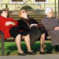Ladies sleeping on park bench